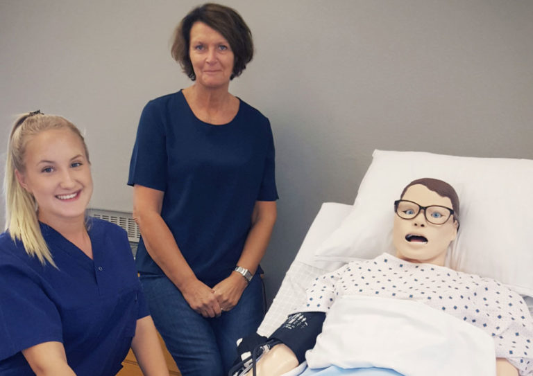 Eleven Hanna Ahl och Programsamordnare Else-Britt Persson tillsammans med dockan som eleverna på skolan har döpt till Kim.