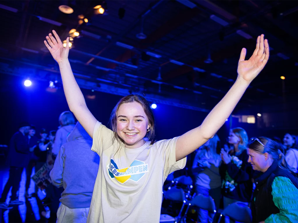 En jubilerande åttaklassare lyfter armarna i luften