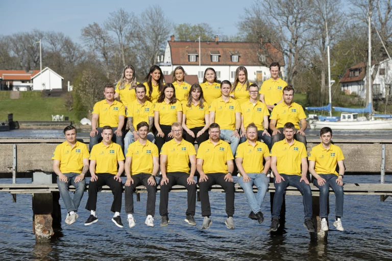 De tävlande i Yrkeslandslaget sitter och står på en brygga i svenska skärgården