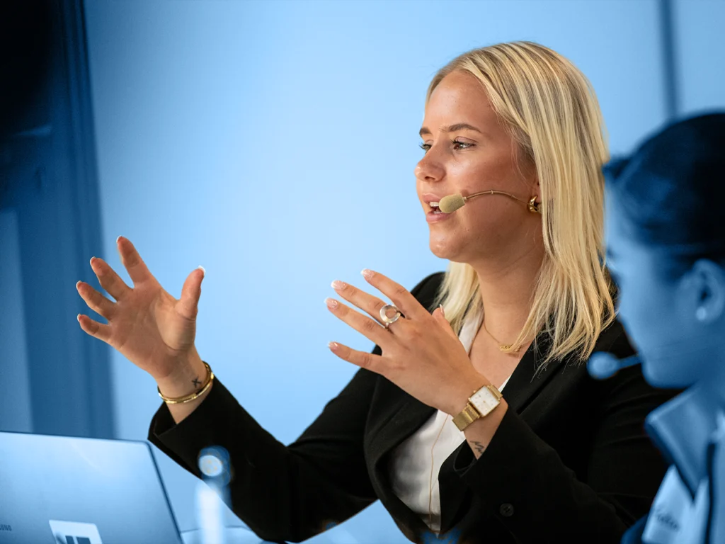 A young woman gestures while she speaks