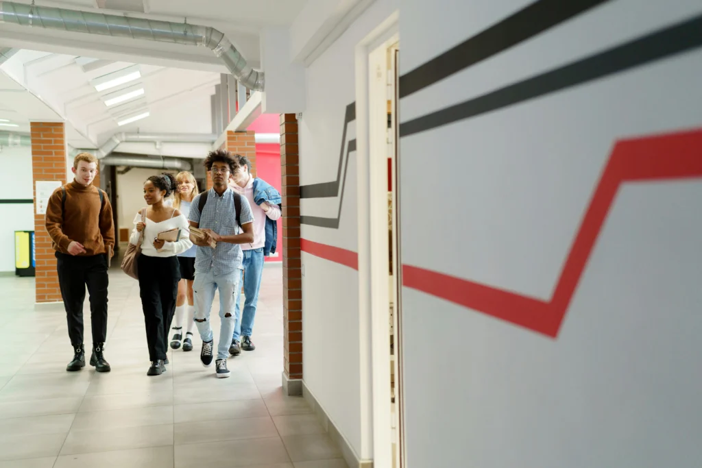 A group of friends walking down a school corridor