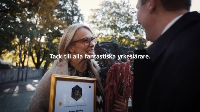 Glad vinnare av Årets Yrkeslärare 2025 håller ett diplom och en bukett med blommor.